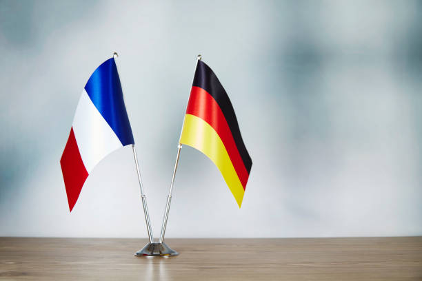 French and German flag standing on the table with defocused background
